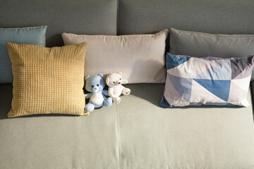 The sofa where there are pillows and baby dolls