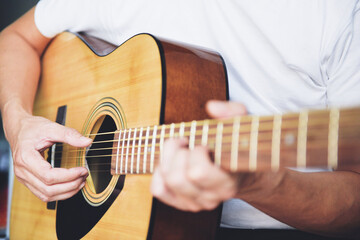 Man hands playing acoustic guitar, close up guitar player.