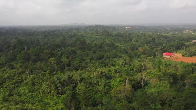 Aerial home in Ghana Jungle greel landscape. Roads, streets are poorly maintained rough dirt. Cultural capital of historical Ashanti Empire. Third world poor poverty areas with small shacks.