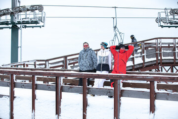 Skiers posing against the background of the ski lift