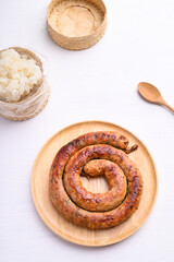 Northern Thai sausage (Sai Aua), Grilled intestine stuffed with minced pork, spices and herbs eating with sticky rice on white background, popular food in Chiangmai, Thailand