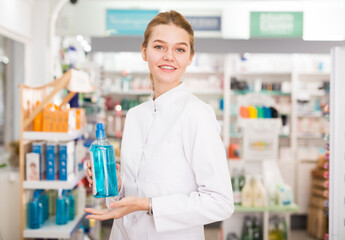 Smiling young pharmacist ready to assist in choosing at counter in pharmacy. High quality photo