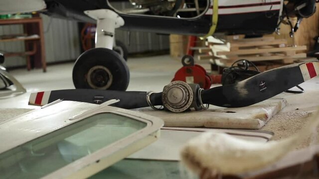 Airplane Propeller Lying On Floor Of Hangar Among Other Parts