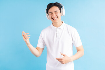 a photo of a handsome Asian boy listening to music and following the music