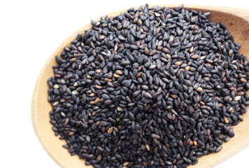 Black sesame seeds in wooden spoon.