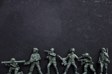 Miniature toy soldiers on black background