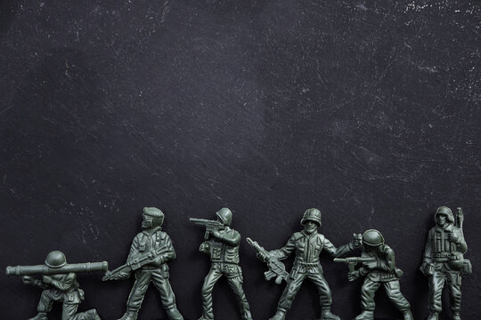 Miniature toy soldiers on black background
