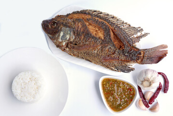 Fried tilapia fish with spicy sauce. Top view.