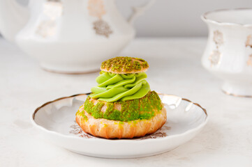 Pistachio cream cake and white tea set on the table