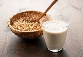 Soy milk in a glass on a wooden background