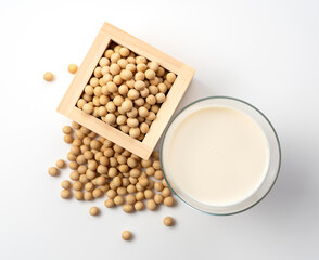 Soy milk and soybeans in a glass placed on a white background