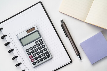 Top view of notebook with pen, sticky note  and calculator with white isolated background 