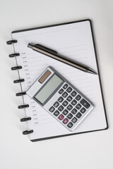Top view of notebook with pen and calculator with white isolated background 