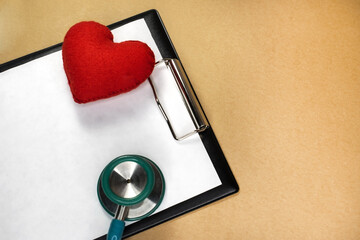 The stethoscope and the red heart are located on a stationery tablet with space for text. The...