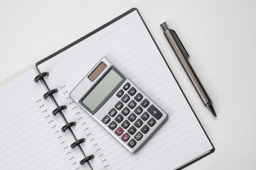 Top view of notebook with pen and calculator with white isolated background 