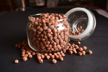 Closeup Brown Chickpea Beans in a Transparent Glass Jar On isolated Black Background