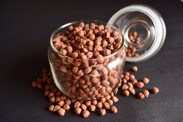 Closeup Brown Chickpea Beans in a Transparent Glass Jar On isolated Black Background