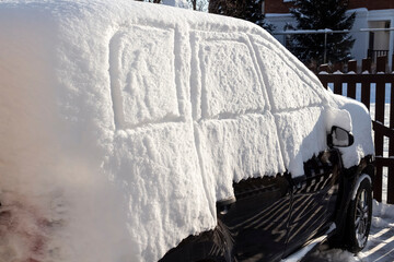 The car was completely covered with snow in the backyard.