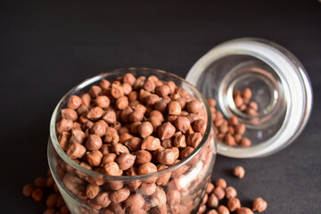 Closeup Brown Chickpea Beans in a Transparent Glass Jar On isolated Black Background