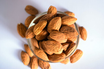 Organic Almond Nuts in a Transparent Glass Bowl On isolated White Background