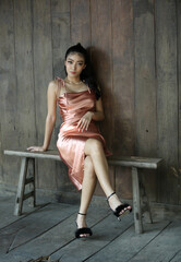 elegant sensual young woman in brown dress on recamier outdoor shot