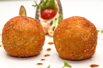 Chicken Kiev and roasted vegetables on a white plate, a white background. Breaded chicken breast stuffed with herbs and butter, close up view