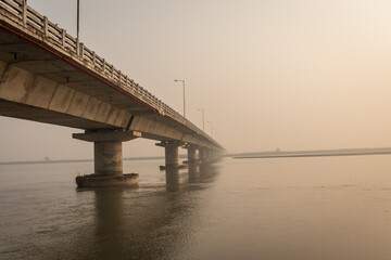 road bridge over river with its water reflection at dawn from low angle