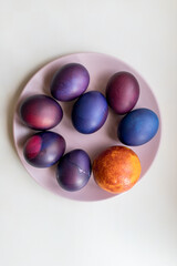 Painted blue and purple Easter eggs on a textured background. Easter eggs on a plate.