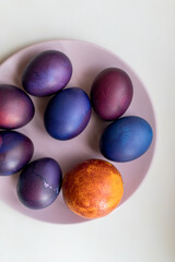 Painted blue and purple Easter eggs on a textured background. Easter eggs on a plate.