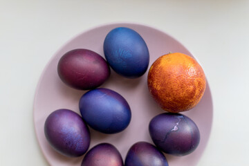 Painted blue and purple Easter eggs on a textured background. Easter eggs on a plate.