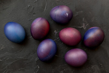 Painted blue and purple Easter eggs on a textured background. Easter eggs on a plate.