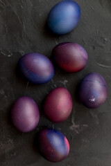 Painted blue and purple Easter eggs on a textured background. Easter eggs on a plate.