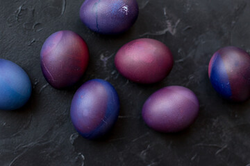 Painted blue and purple Easter eggs on a textured background. Easter eggs on a plate.