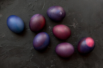 Painted blue and purple Easter eggs on a textured background. Easter eggs on a plate.