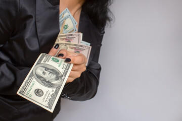 Female hands hold dollar bills.