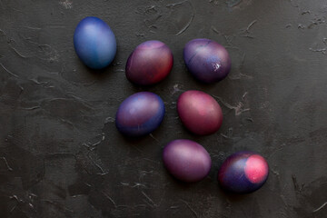 Painted blue and purple Easter eggs on a textured background. Easter eggs on a plate.