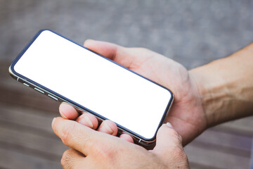 Close up of men hands holding touching mobile phone with blank copy space for your text message in cafe  with light Sunset,Vintage tone.Selective focus
