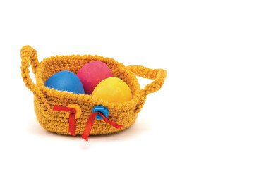 Painted eggs lie in a knitted basket.