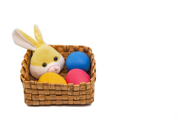 Painted eggs and a rabbit lie in a wicker basket.