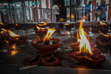 small burning lamp at temple offerings