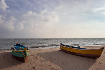 Naklejka na ściany i meble Fishing boat isolated on the sandy beach with amazing sky