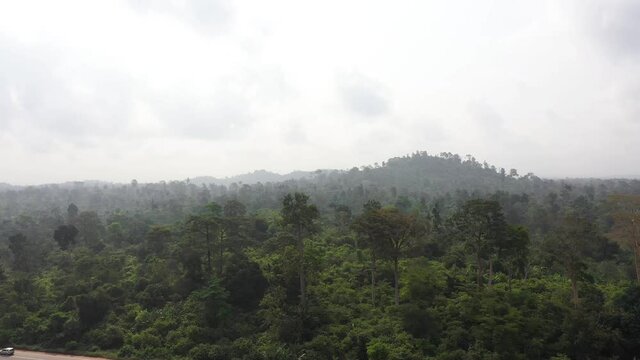 Aerial main highway out of Accra Ghana jungle tropica. Roads, streets are poorly maintained rough dirt. Cultural capital of historical Ashanti Empire. Third world poor poverty areas with small shacks.