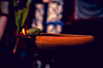 Creative Photography of A Realistic Burning Mud Oil Lamps in Diwali, An Indian Festival in Evening. Colorful Red, Yellow, Orange Fire Flame Lit on Dark Night Shadow Background with Noise Grain Effect.
