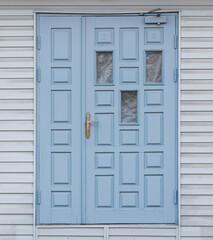pale blue front door in a wooden wall
