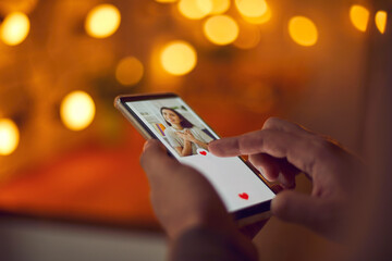 Find love online concept. Man holding mobile phone, looking at attractive young woman's profile...