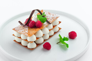 raspberry mille feuille dessert with whipped sour cream on a white plate