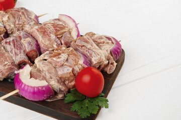 Raw marinated kebab on skewers on wooden background