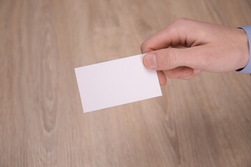 Obraz premium Hand hold blank white card mockup with rounded corners. Plain call-card mock up template holding arm. Plastic credit namecard display front. Check offset card design. Business branding.