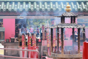 Chinese New Year concept. Temple in Hong Kong with smoke of many incenses stick. People come to pray and wish for best thing as rich and healthy.