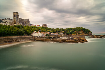 Naklejka premium Seascape in Biarritz France in long photographic exposure. Dramatic sky. 